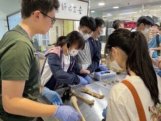 Medical students explained to participants the specimen at dissecting laboratory