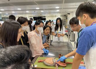 Medical students explained to participants the specimen at dissecting laboratory