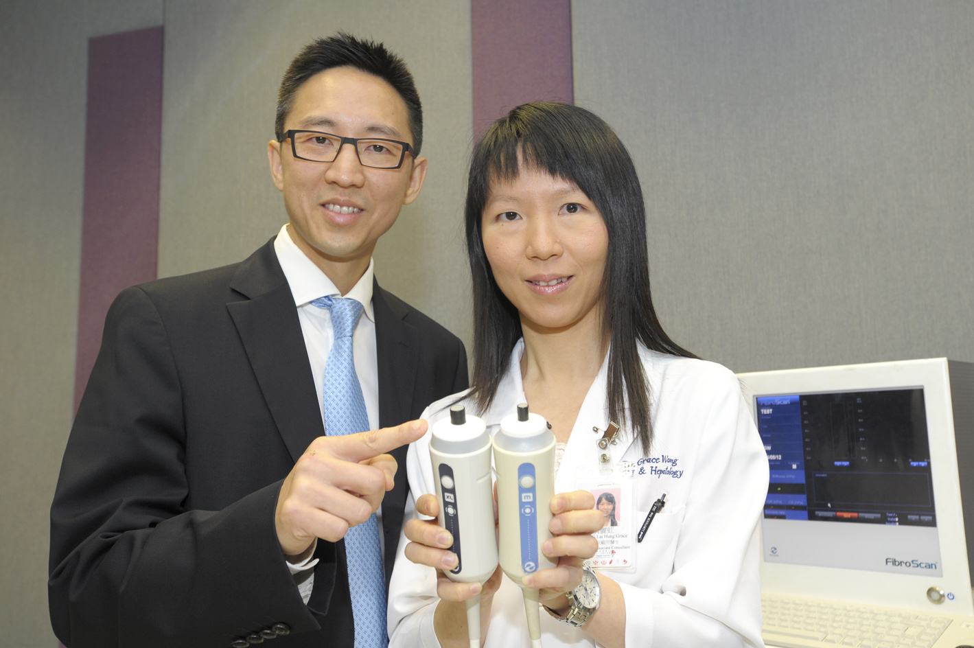 陈力元教授与黄丽虹教授展示无创肝纤维化扫瞄器的加大码探头(左方) 和正常探头(右方)