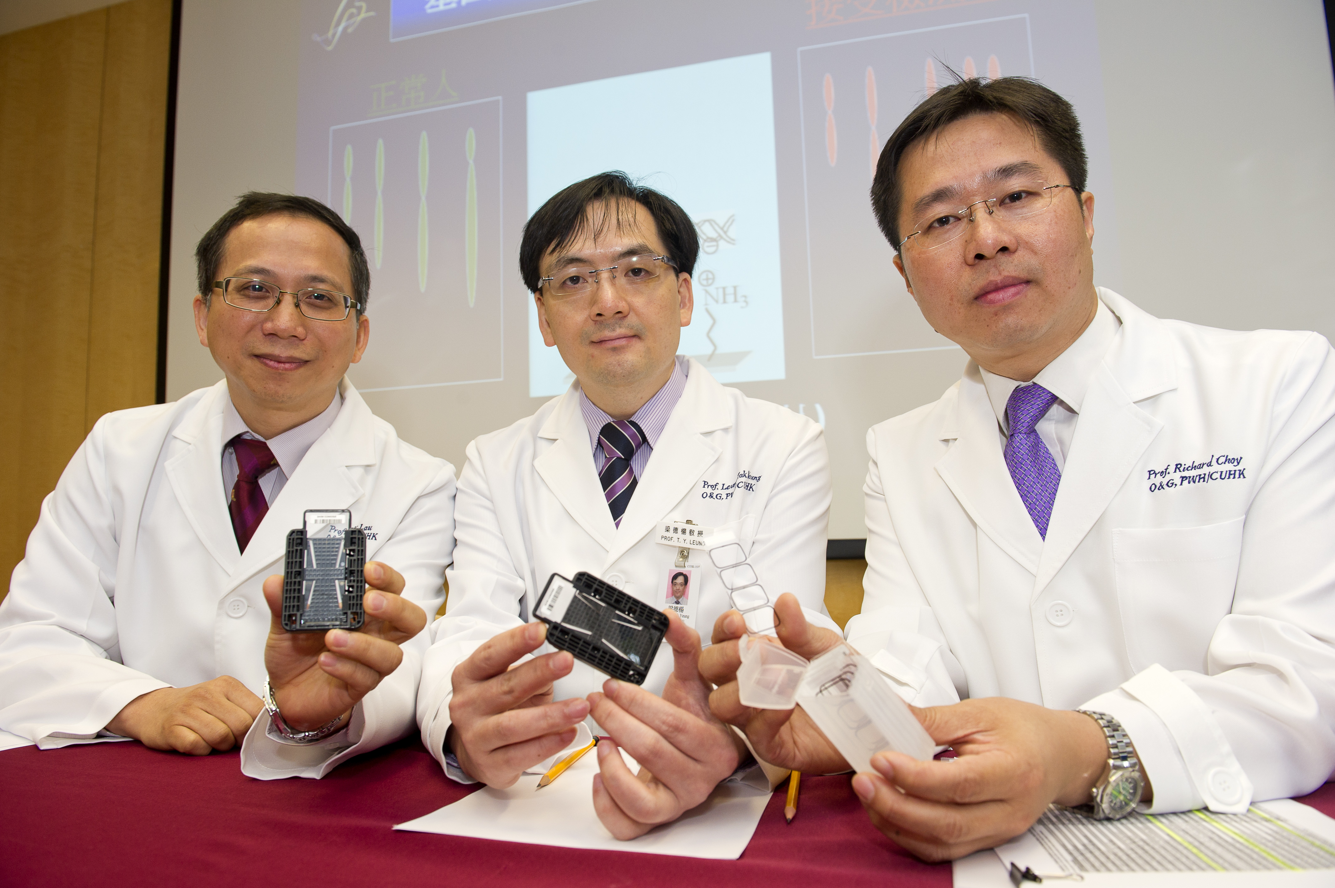 (from left) Prof. Tze Kin LAU, Clinical Professor (honorary); Prof. Tak Yeung LEUNG and Prof. Richard Kwong Wai CHOY, Associate Professor, Department of Obstetrics and Gynaecology, CUHK, show the DNA chip.