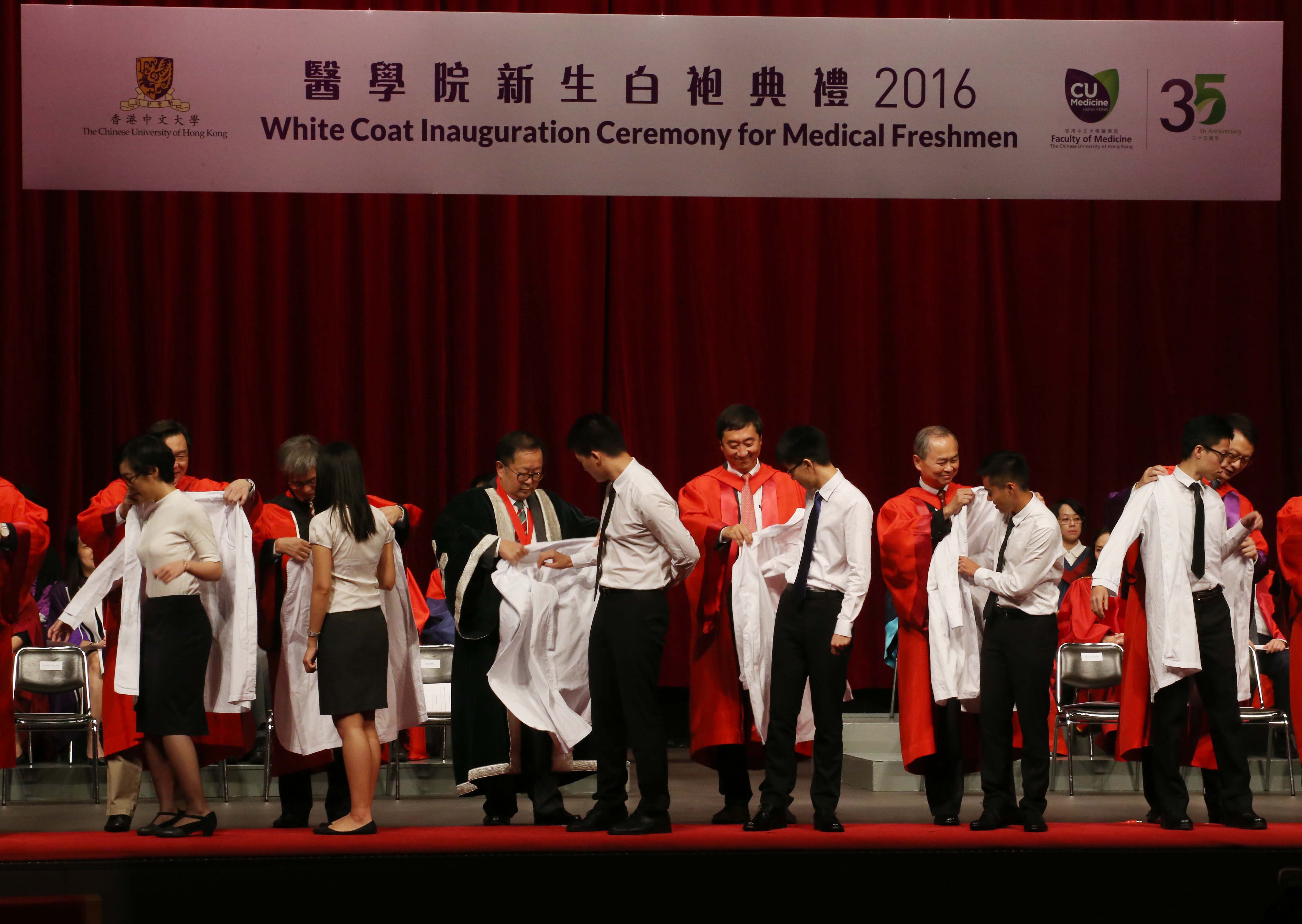 White coats are solemnly conferred on over 200 medical freshmen by Prof. Donald K. T. LI, President of the Hong Kong Academy of Medicine (3rd left, back row); Prof. Joseph SUNG, Vice-Chancellor of CUHK (3rd right, back row); Prof. FOK Tai-fai, Pro-Vice-Chancellor of CUHK (2nd right, back row); Dr HUNG Chi-tim, Cluster Chief Executive, New Territories East Cluster, Hospital Authority (2nd left, back row); and Prof. Francis CHAN, Dean of the Faculty of Medicine, CUHK (1st right, back row) and Prof. WING Yun-kwok, Associate Dean (Student Affairs) of the Faculty (1st left, back row) in the White Coat Inauguration Ceremony 2016.