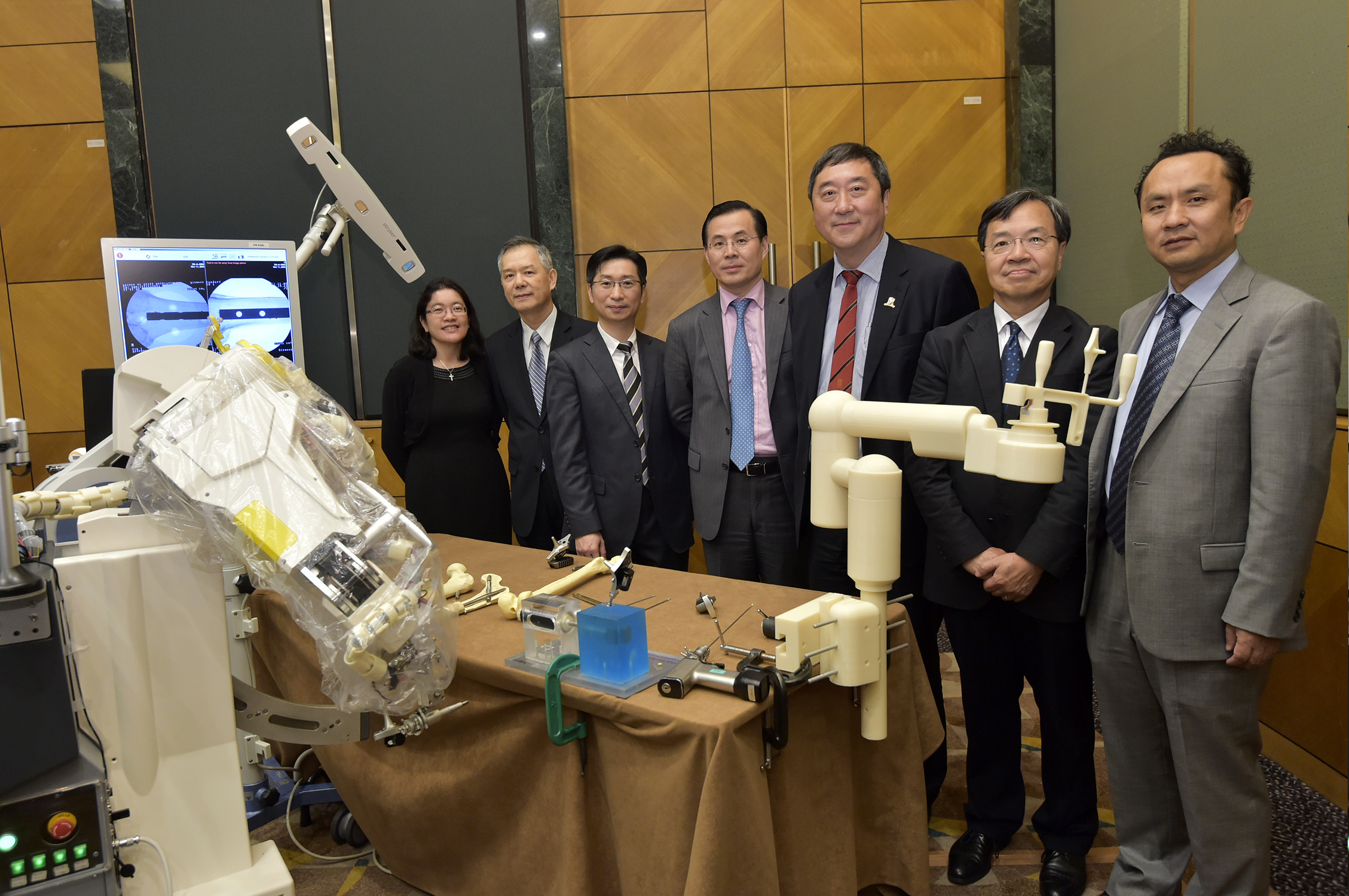 A group photo of the three officiating guests and CUHK researchers involving in the development of biomedical robotics